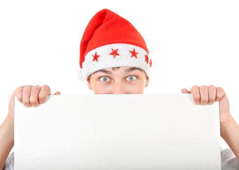 Surprised Teenager in Santa's Hat behind Empty White Board Isolated On The White Background