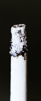 Smoking a cigarette against a dark background