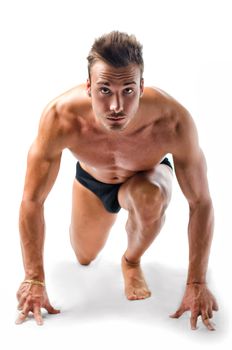 Attractive young man with muscular naked body ready to sprint and run