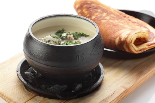 hot roasted meat with pancake and mushrooms on wooden desk