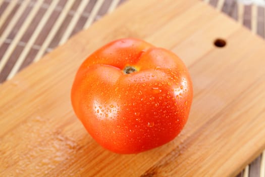 fresh tasty and wet tomato on wooden background