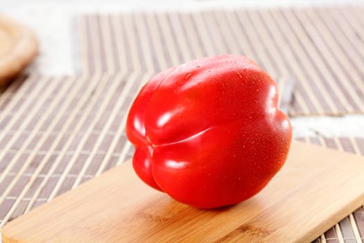 fresh tasty and wet pepper on wooden background