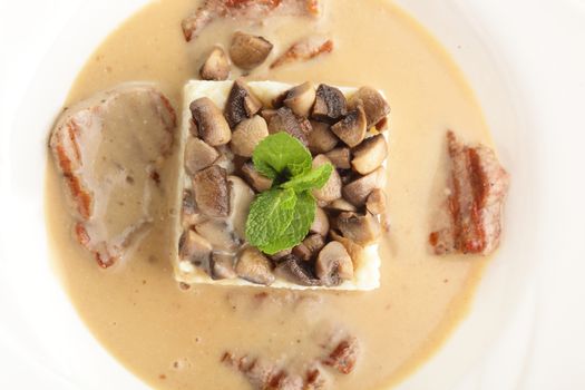 hot roasted meat with rice and mushrooms on white background