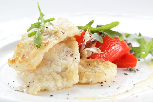 roasted peaces of fish with garnish on white background