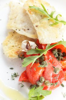 roasted peaces of fish with garnish on white background