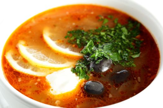 hot soup with sauce and lemon on white background