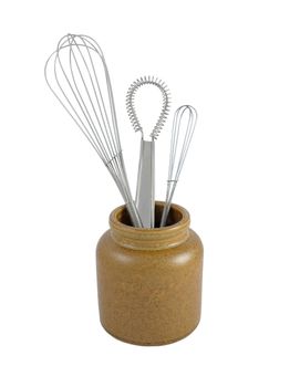 Three metal whisks in a brown ceramic jar, isolated on a white background 