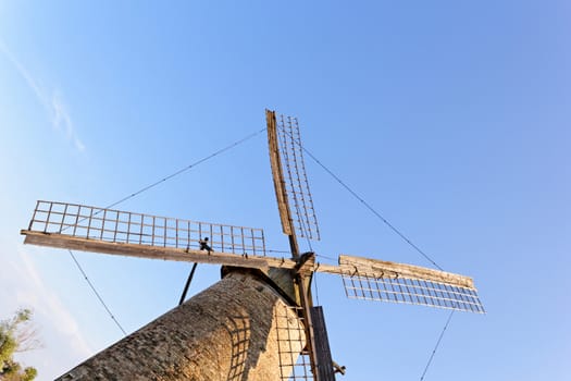 Old wooden windmill against the blue sky