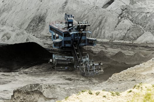 Coal mining in an open pit with huge industrial machine