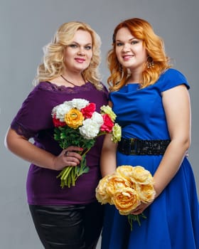 Attractive mother and daughter in a family photo with flowers in their hands