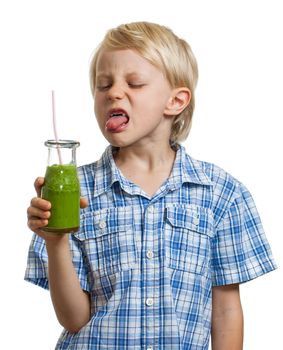 A funny boy poking his tongue out at a green smoothie. Isolated on white.