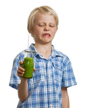 A funny boy holding a green smoothie looking disgusted. Isolated on white.