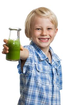 A happy smiling boy holding out a bottle of green smoothie or juice. Isolated on white.