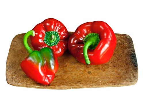 Red ripe sweet  pepper on wooden board isolated over white