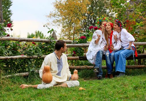 Young people dressed in Ukrainian style clothing shirts flirting