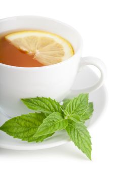 Tea with piece of lemon and mint on a plate over white background