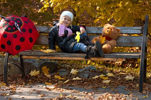 Pretty little girl relax on beauty autumn landscape background