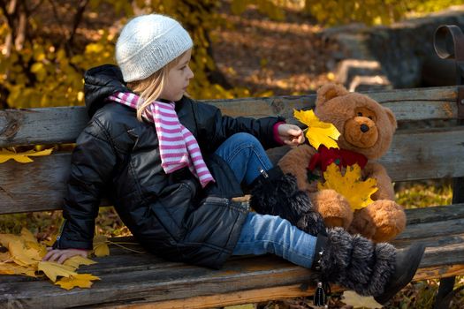 Pretty little girl relax on beauty autumn landscape background