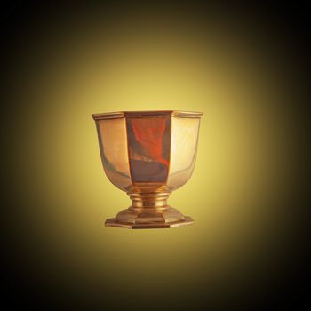 Golden cup mimic of Holy Grail over golden and black background