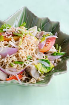Thai dressed spicy salad with pork, tomatoes and noodle. 