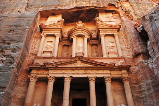 Al Khazneh ("The Treasury"; Arabic: الخزنة‎) is one of the most elaborate temples in the ancient Jordanian city of Petra. As with most of the other buildings in this ancient town, the structure was carved out of a sandstone rock face. It has classical Greek-influenced architecture, and it is a popular tourist attraction.