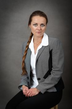 Portrait of middle age business woman on grey background with shallow focus