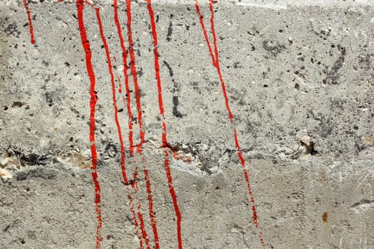 Streaks of red paint on a concrete wall as a texture