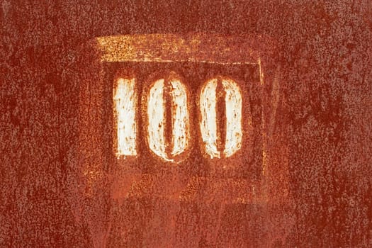 Number 100 painted on an old rusty metal surface as a texture