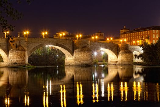 old stone bridge through the river Ebro in Zaragoza, Spain