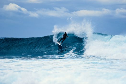 Surfer riding on a large wave on the Atlantic Coast. Canary island, Spain