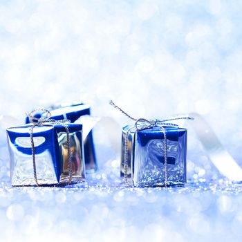 Silver christmas gifts on glitter shiny background close-up