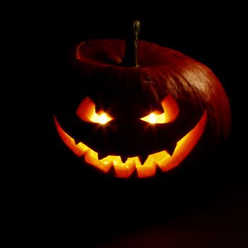 Halloween pumpkin with scary face on black background