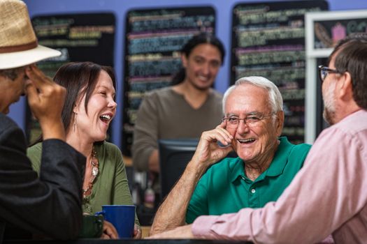 Mature people in a coffee house laughing