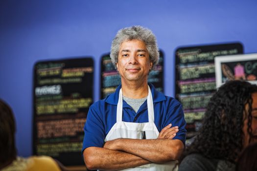 Confident African coffee house owner with folded arms