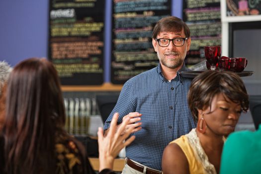 Customer signalling waiter with drinks on trays