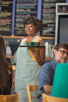 Gorgeous barista in apron working in coffee house