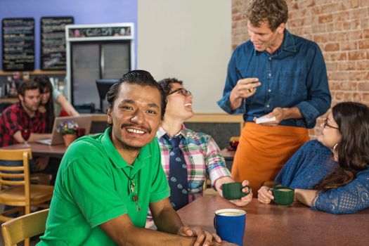 Grinning Asian man with friends and barista