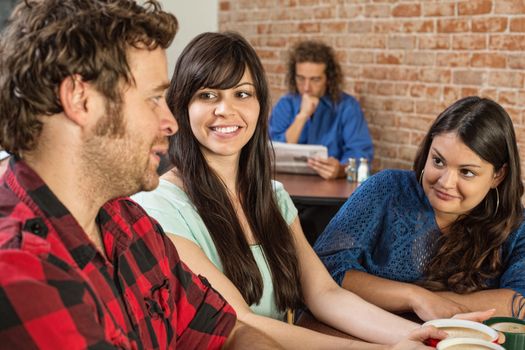 Three friends in a coffee house talking