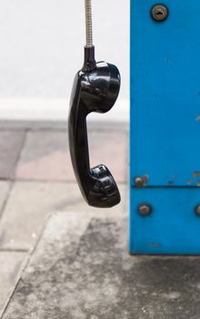 One black handset hanging in a row