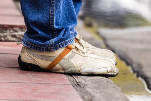 Ripped shoes, waiting someone at a bus stop in Bangkok, Thailand