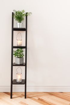 Shelf with plants and lanterns decorating a living room.