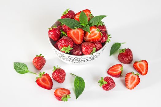 Ripe strawberries and mint leaves, on white background.