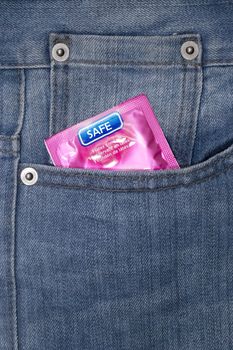 Pink wrapped condom on a demin jean pocket