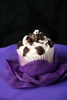 Close up of a decadent gourmet cupcake with chocolate and vanilla frosting. 