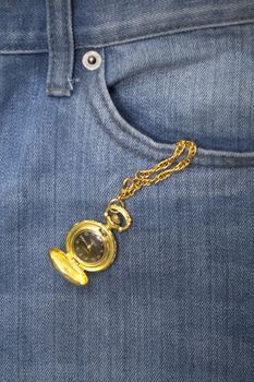 Gold watch in a denim jeans pocket