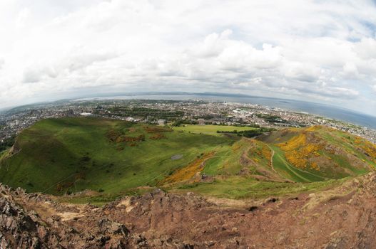 Arthur's Seat is the main peak of the group of hills which form most of Holyrood Park. It is situated in the centre of the city of Edinburgh, about a mile to the east of Edinburgh Castle. The hill rises above the city to a height of 250.5 m (822 ft), provides excellent panoramic views of the city, is relatively easy to climb, and is popular for hillwalking.