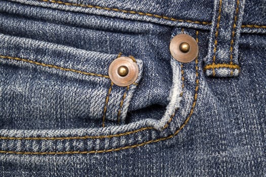 Close up image of denim jeans pocket with a ripped hole