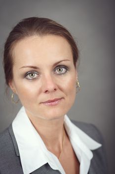 Portrait of middle age business woman on grey background with shallow focus