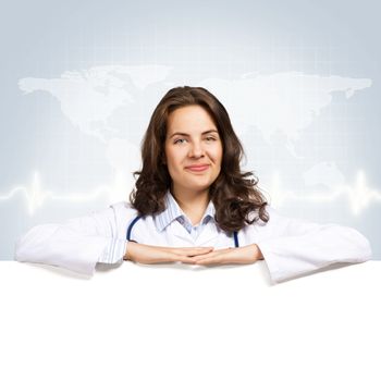 Young attractive female doctor put her hands on the blank banner, place for text