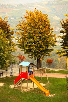 Lone children's slide on empty playground in autumn in small town of Diano D'Alba, Italy.